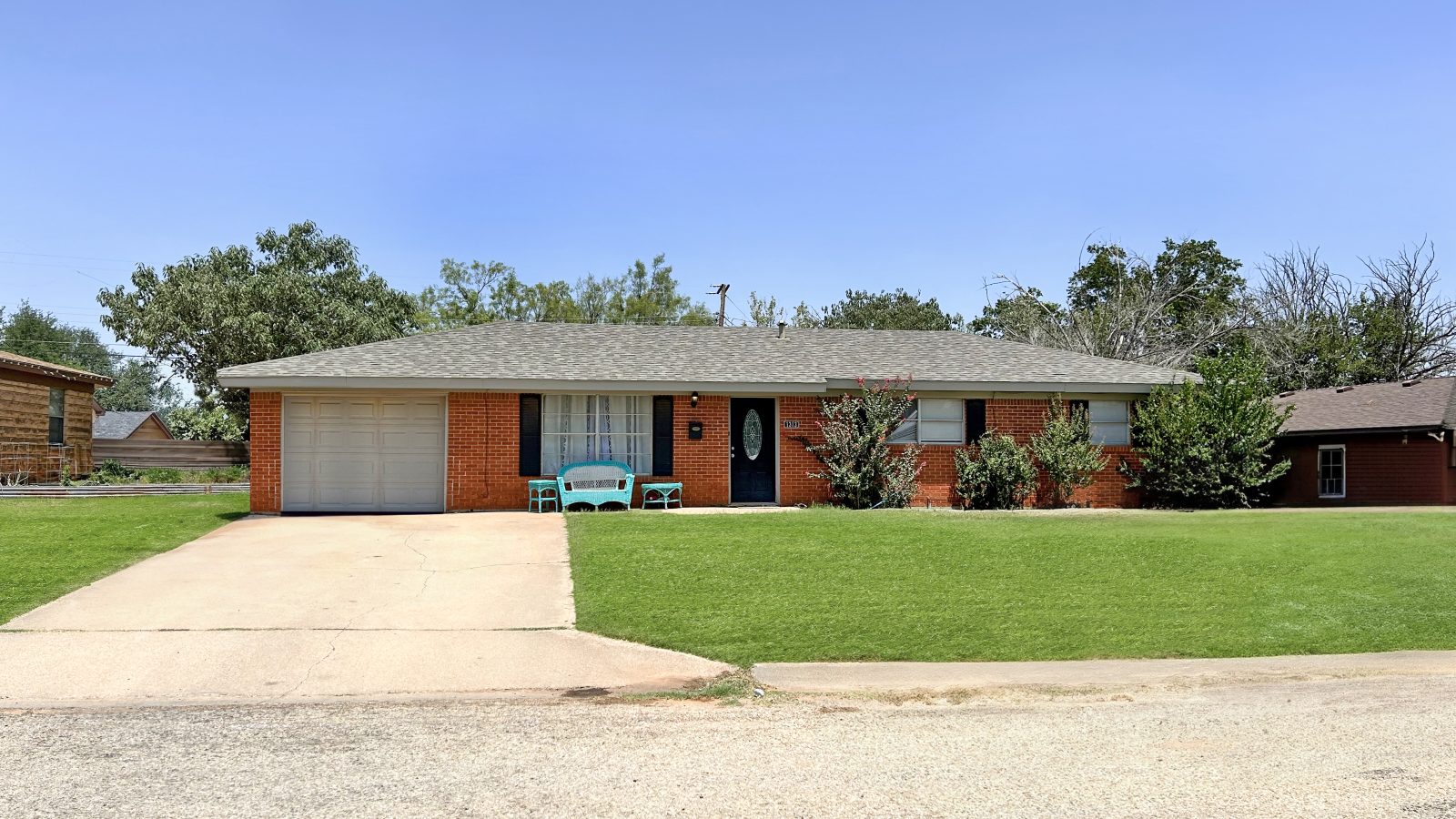 red brick house, large driveway, large front yard, grey roof
